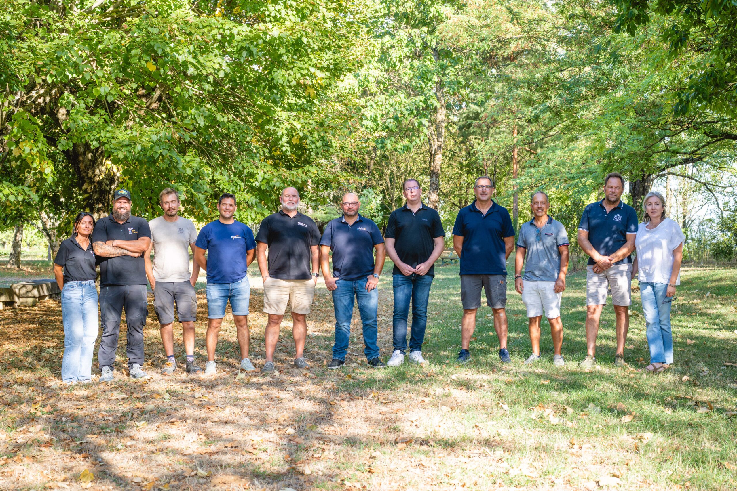 Portrait de groupe des artisans membres de Coop’Renov dans un parc à Albi
